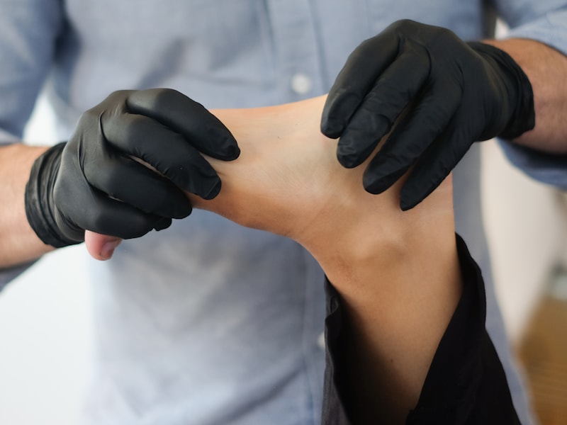 A clinician in gloves treating a client's shoulder as part of a rehabilitation appointment